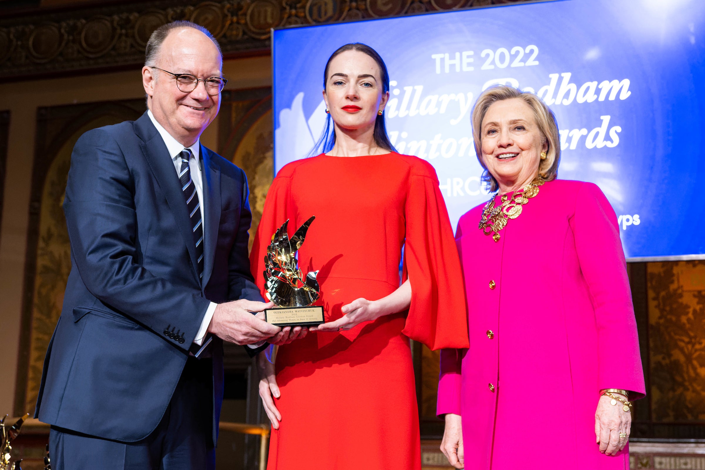 Jack DeGioia, Oleksandra Matviychuk and Hillary Clinton hold an award onstage